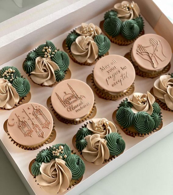 twelve decorated cupcakes in a box on a table