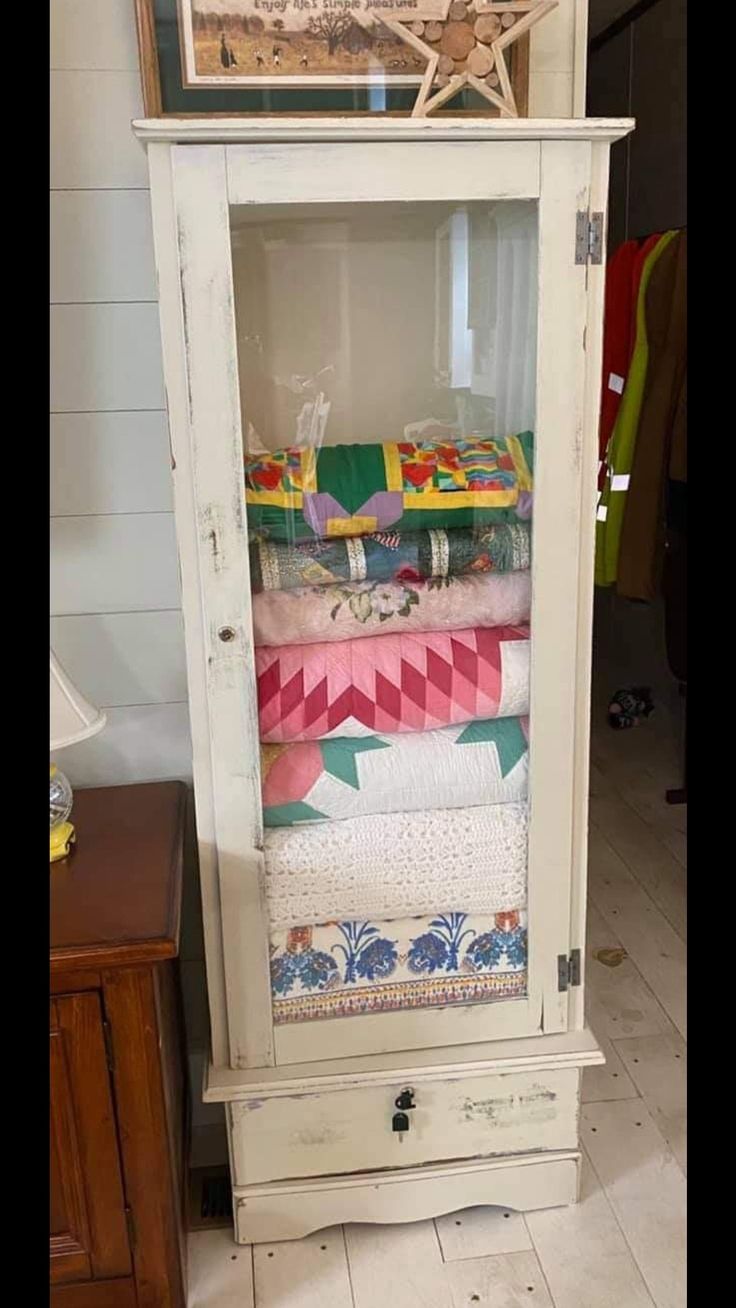 a cabinet with many different colored fabrics in it