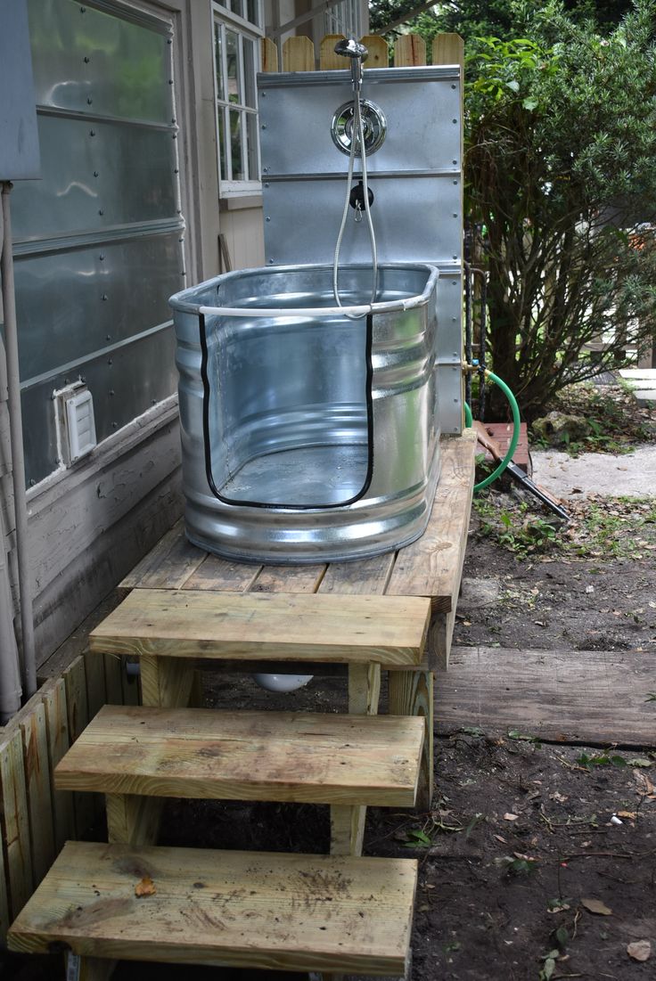 a metal tub sitting on top of wooden steps