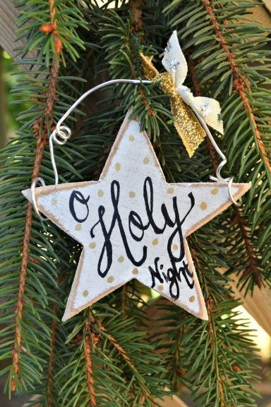 a wooden star ornament hanging from a christmas tree with the words, holly night on it