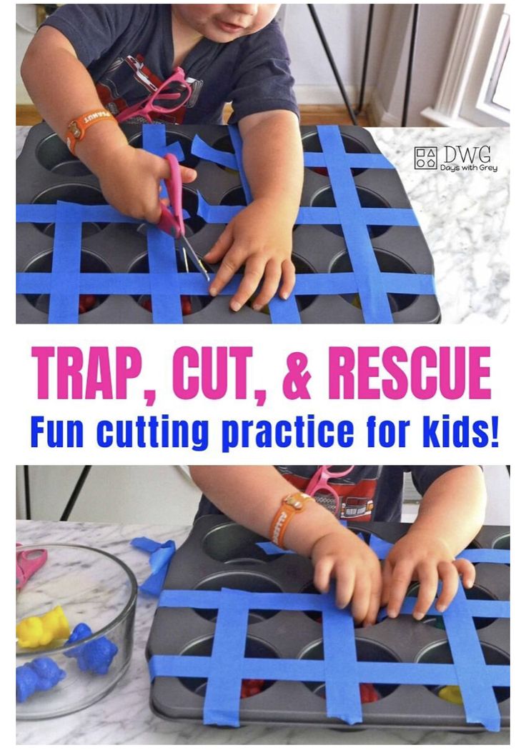 a young child cutting out pieces of construction paper with scissors and tape on the table