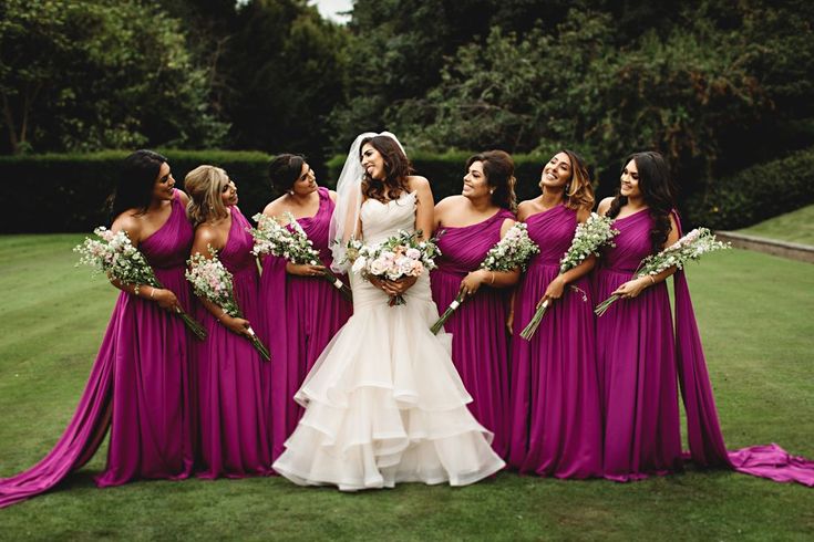 a group of women standing next to each other in purple dresses