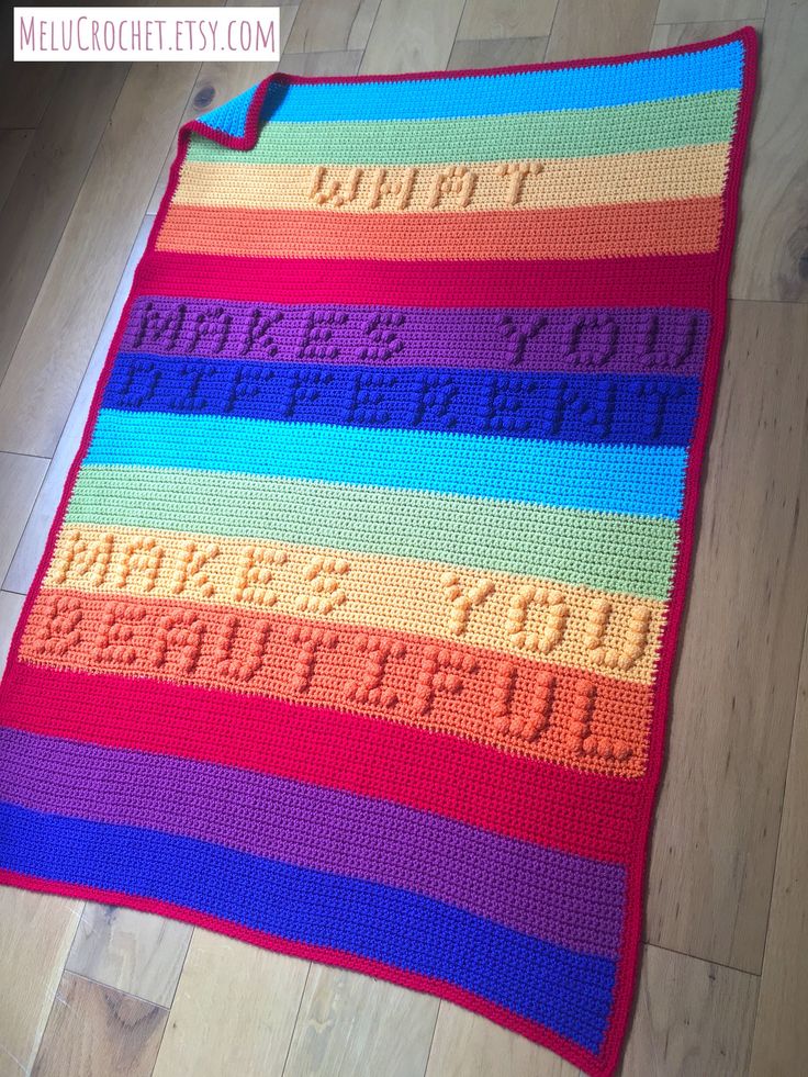 a crocheted blanket with words written on it in multicolored yarns