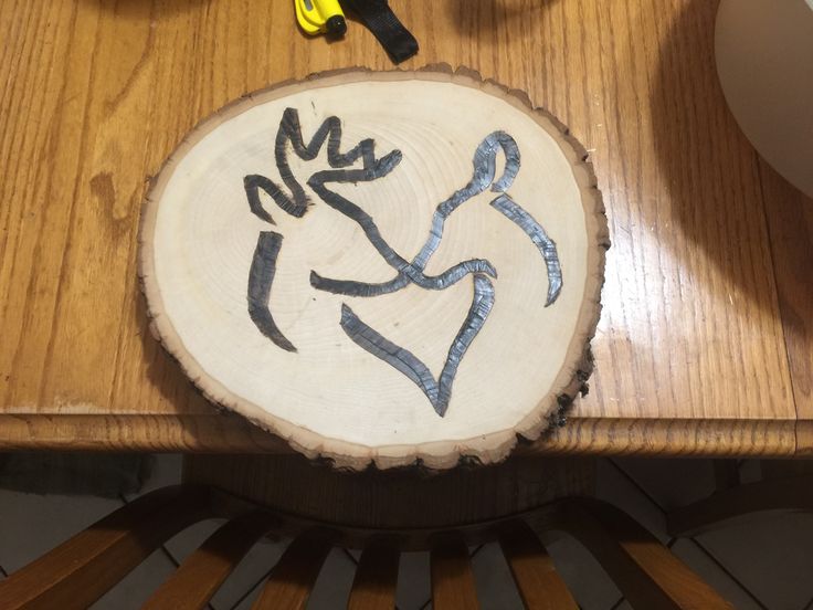 a piece of wood that has been painted with blue and black designs on it, sitting on a table