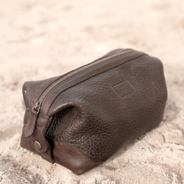 The Lucchese Dopp Kit is a perfect match to the overnight duffle or rolling duffle. An extra-wide zippered opening makes it easy to stash your essentials. Three interior pockets help keep small items organized on the road. A snap closure at both ends doubles as a handle. Features: 10" L x 5.5 " W x 6.5" H Constructed from full-grain pebbled cowhide leather Smooth leather trim and elbows contrast with the pebbled leather for interest and added strength at stress points Extra-wide opening for easy Functional Travel Bag With Zipper Closure For Storage, Practical Travel Pouch With Zipper Closure, Practical Travel Pouch With Zipper, Travel Case With Zipper Pocket Shaped As Pouch, Travel Case With Zipper Pocket, Brown Pouch With Zipper Closure For Travel, Everyday Pouch Case With Zipper, Functional Brown Travel Pouch, Brown Luggage With Zipper For Overnight Trips