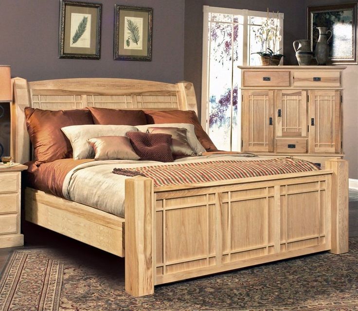 a wooden bed sitting on top of a rug next to a dresser and nightstands