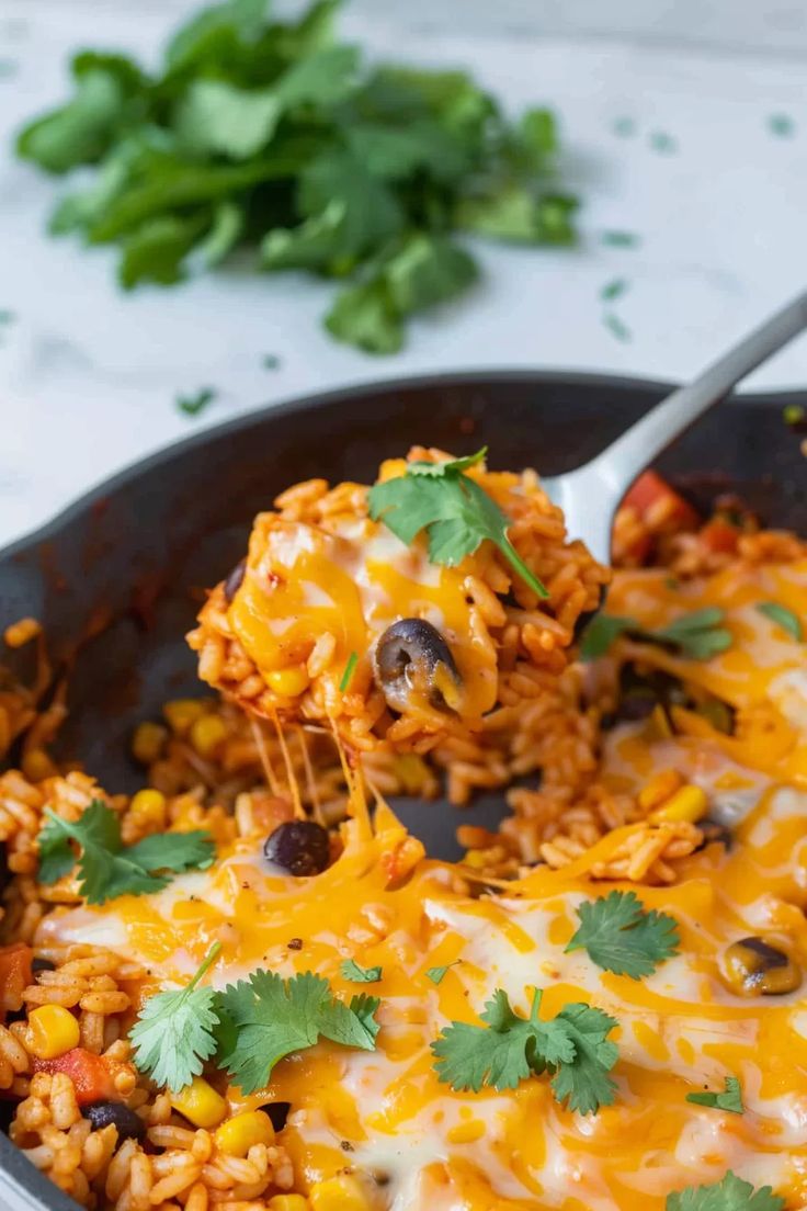 a skillet filled with mexican rice, beans and cilantro garnished with parsley