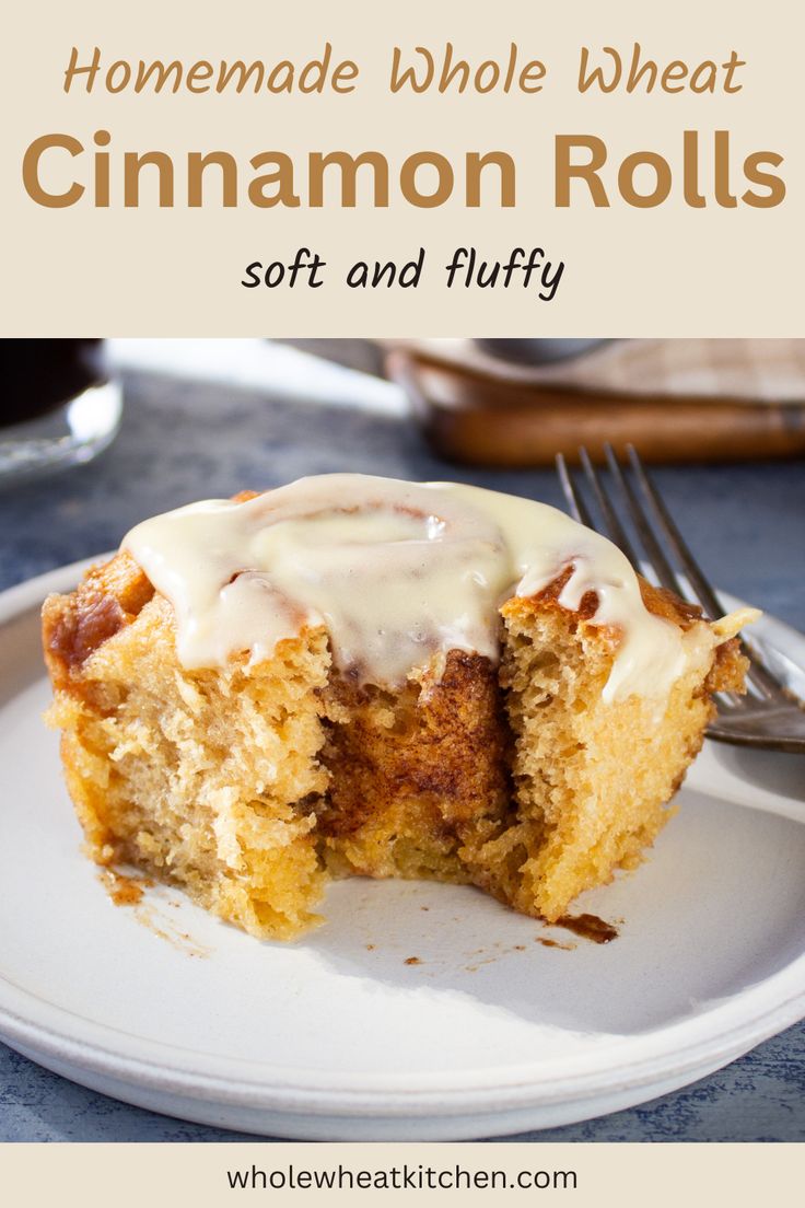 homemade whole wheat cinnamon rolls with icing on a white plate next to a fork