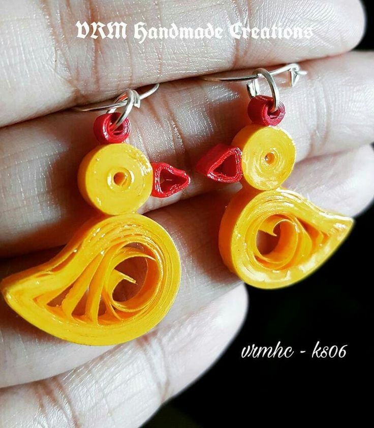 a pair of yellow and red earrings on a person's hand