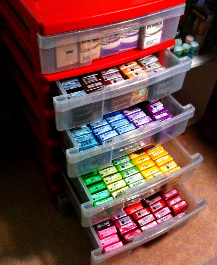 three plastic containers filled with different colored inks on top of a table next to a red drawer