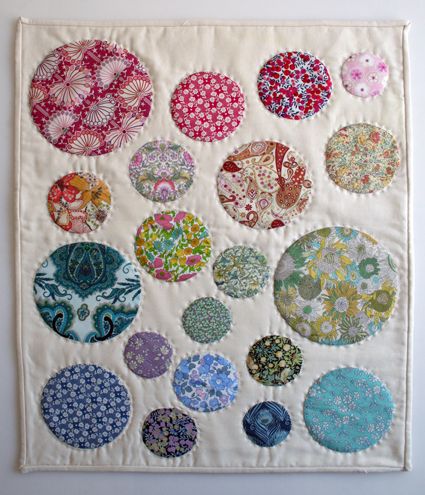 a wall hanging with many different colored circles on it