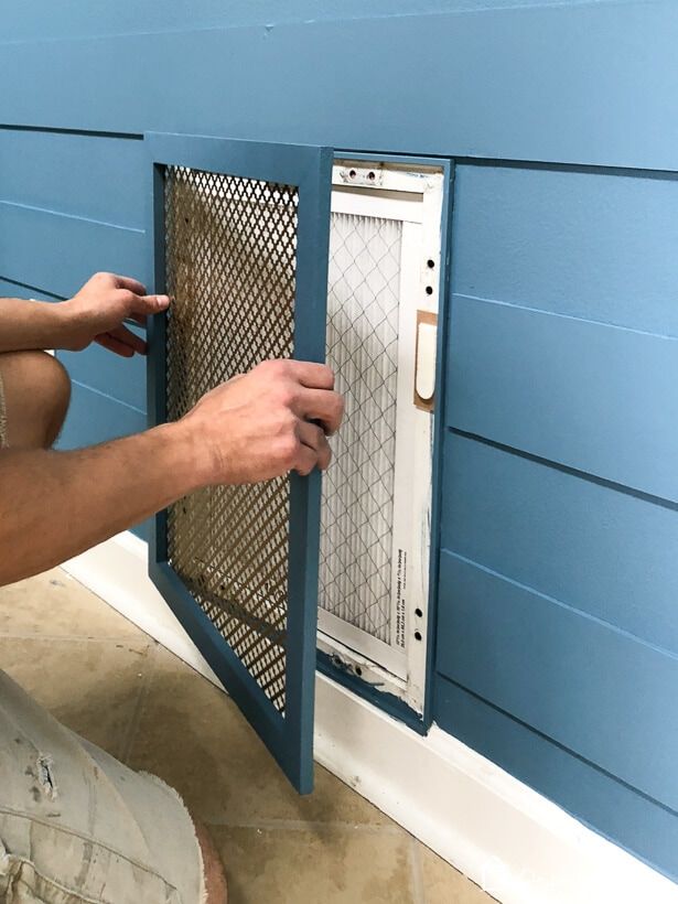 a man is opening the door to his dog house that has been painted blue and white