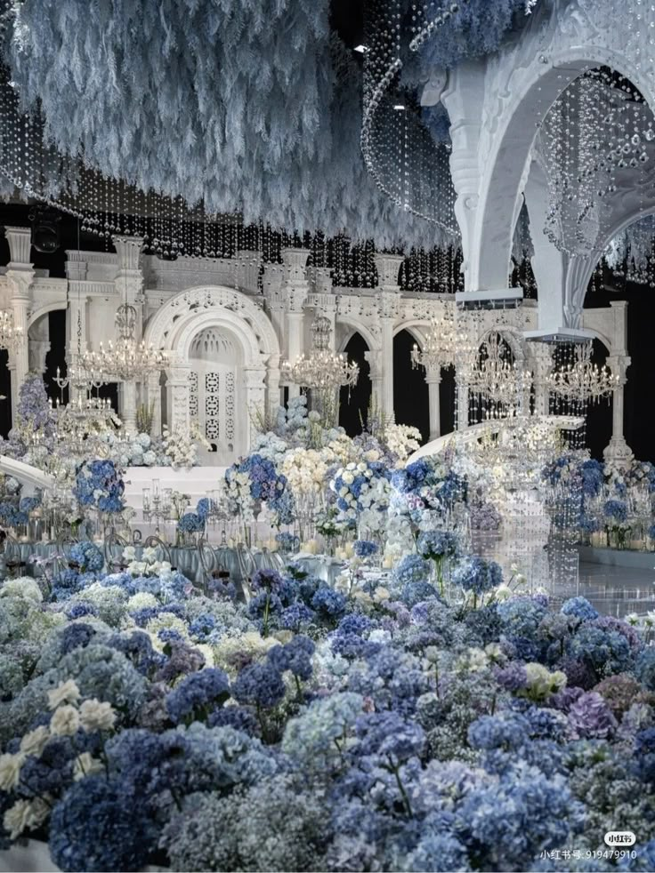 an elaborately decorated building with blue and white flowers in the foreground, surrounded by chandeliers