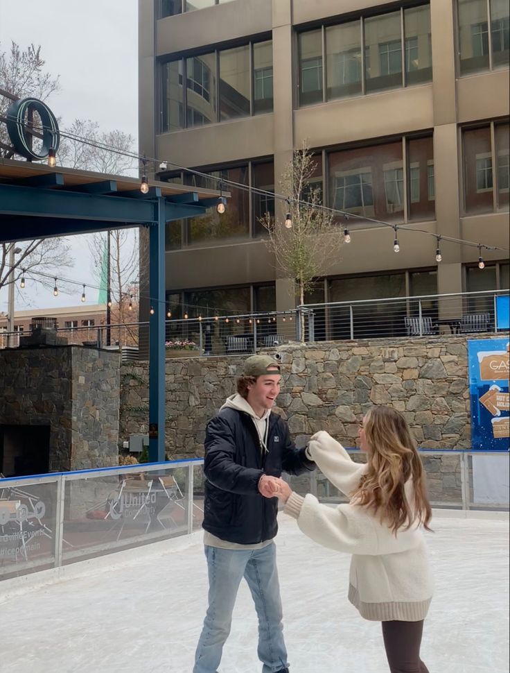 a man and woman are skating on an ice rink