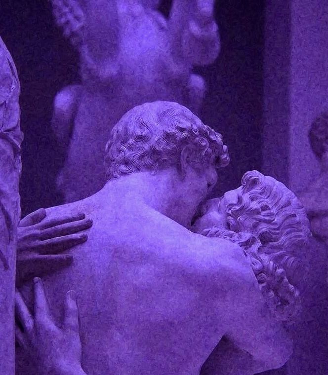 two statues are shown next to each other with purple lighting in the background and one has his arm around another statue