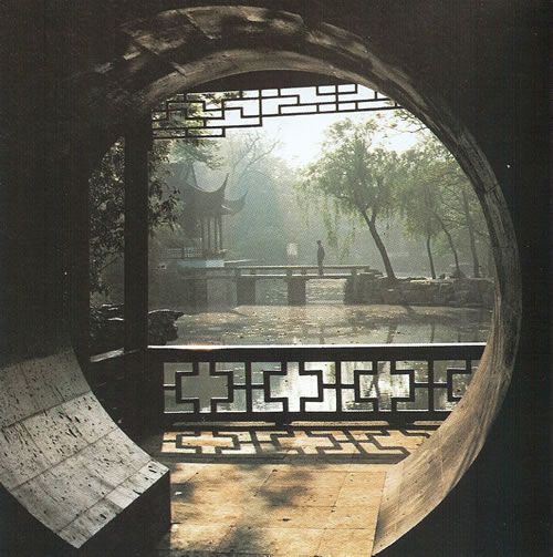 a circular window view of a park with benches and trees