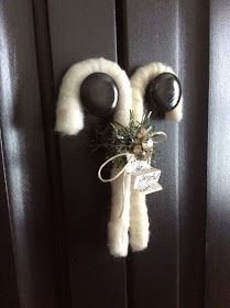 a door handle with two black knobs and a white fur scarf hanging on it