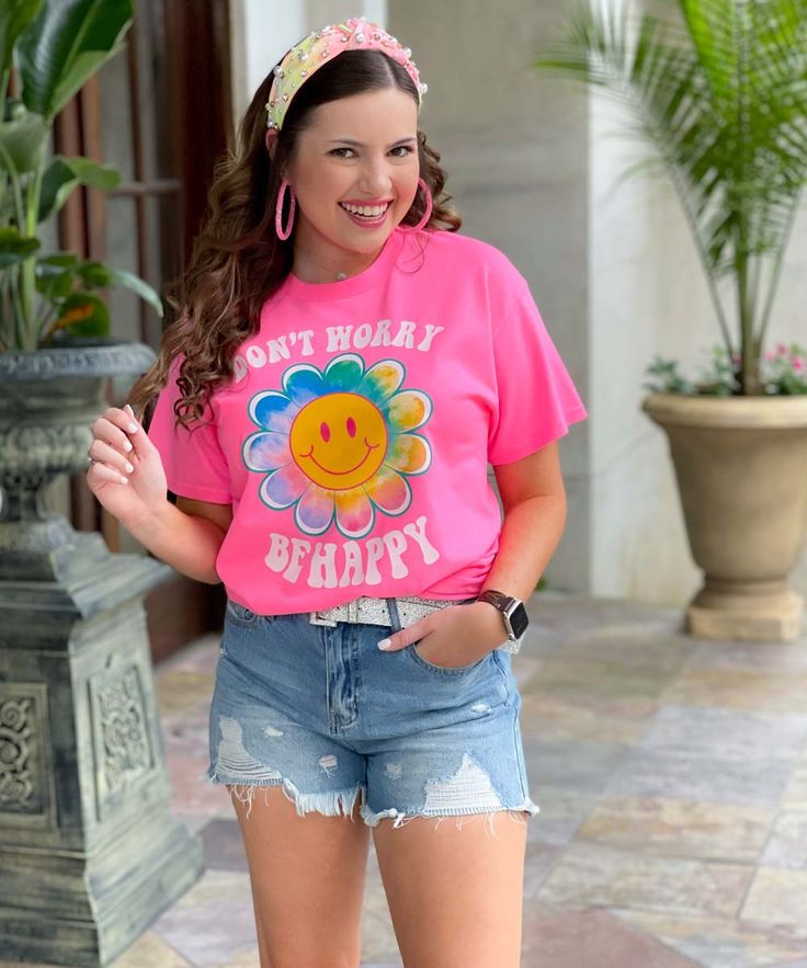 Introducing our Don't Worry Be Happy Flower Smiley Graphic Shirt, a vibrant and uplifting addition to your wardrobe that spreads positivity and joy wherever you go. This captivating shirt features a colorful design on a neon pink background, guaranteed to make a bold statement. The focal point of the design is a cheerful daisy with a smiley face center, radiating happiness and warmth. Encircling the flower are the words "Don't worry be happy," serving as a gentle reminder to embrace a positive m Playful Pink T-shirt For Spring, Playful Pink T-shirt With Slogan, Fun Slogan T-shirt For Spring, Spring Multicolor Slogan T-shirt, Playful Pink Relaxed Fit T-shirt, Pink Letter Print T-shirt For Spring, Spring Pink T-shirt With Graphic Print, Pink Graphic Print T-shirt For Spring, Playful Spring T-shirt With Funny Print