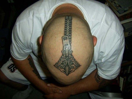 a man with a tattoo on his head is looking down at the ground while wearing a white t - shirt