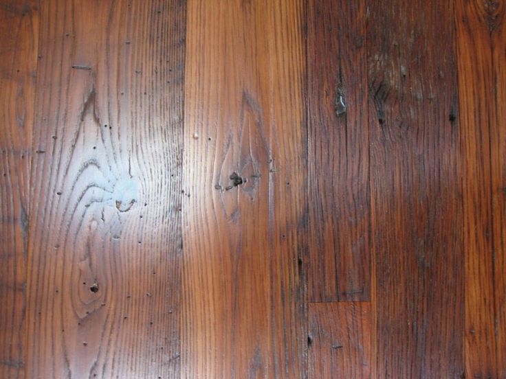 the wood floor is brown and has peeling paint on it's sides, which shows signs of age