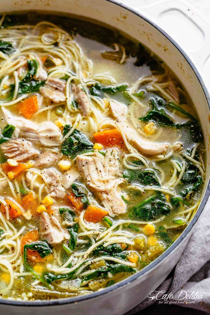 a pot filled with chicken noodle soup on top of a table