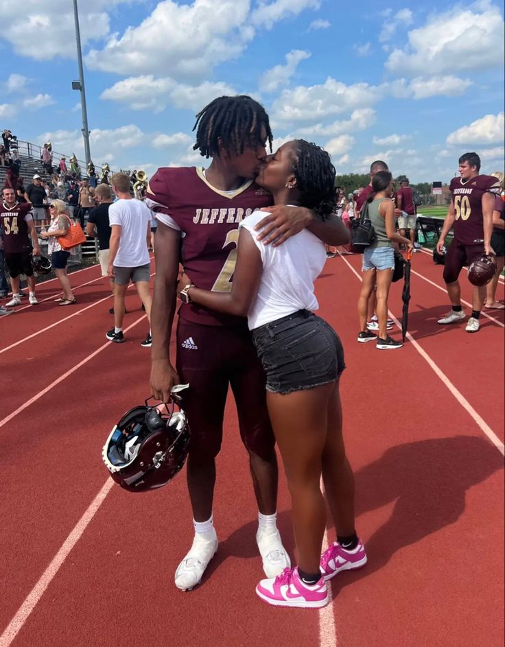 two girls embracing each other on a football field