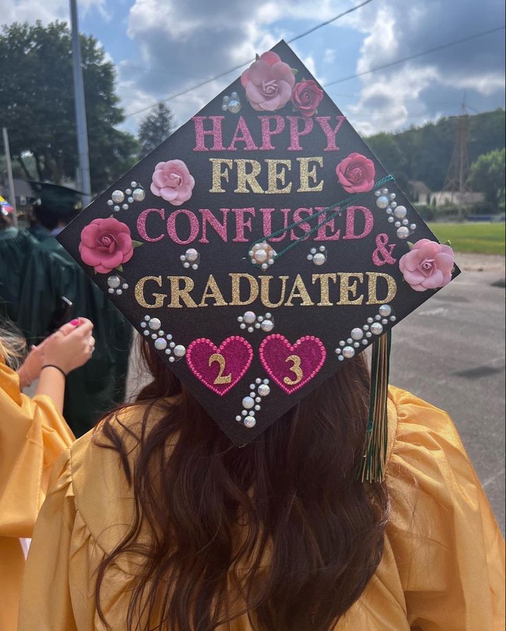 a graduation cap with the words happy free confused and graduate written on it in pink flowers