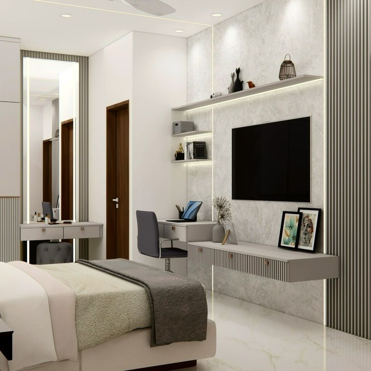 a bedroom with a bed, desk and television on the wall next to a mirror