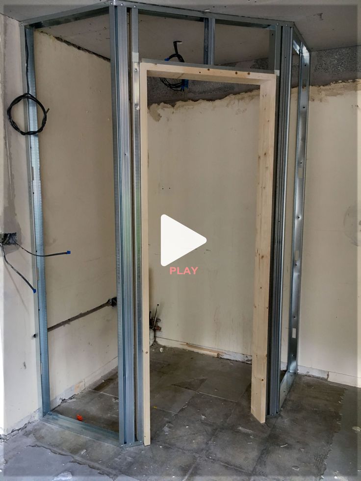 a room that is being remodeled with the door open to reveal a play button on the wall