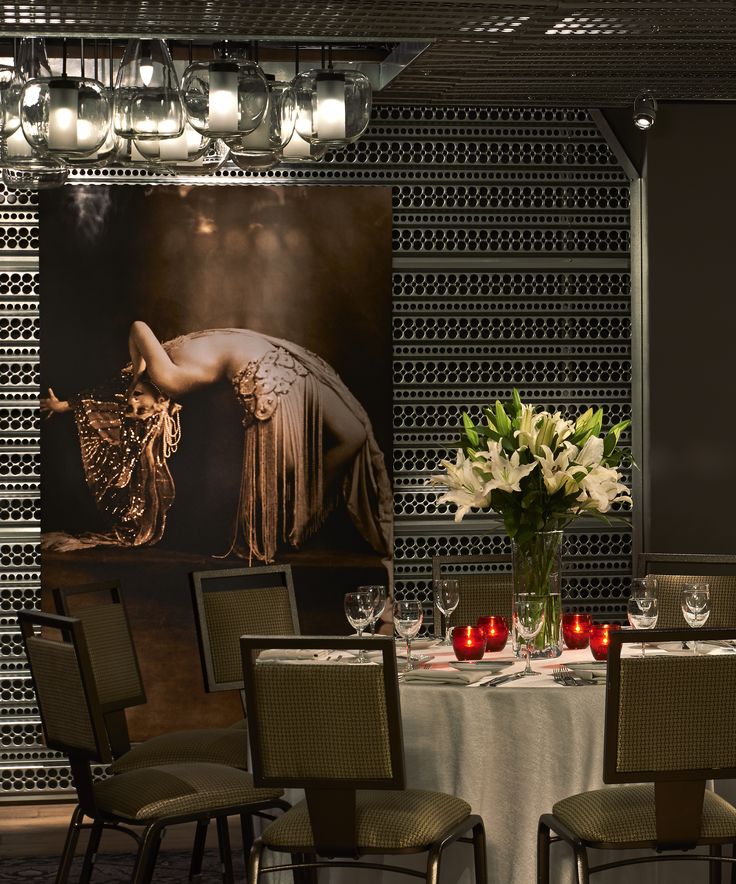 a dining room table with chairs and a large painting on the wall