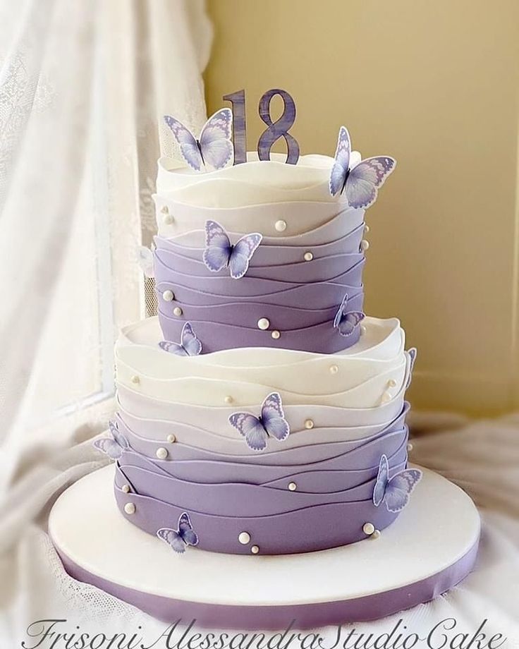 a three tiered cake with purple butterflies on it