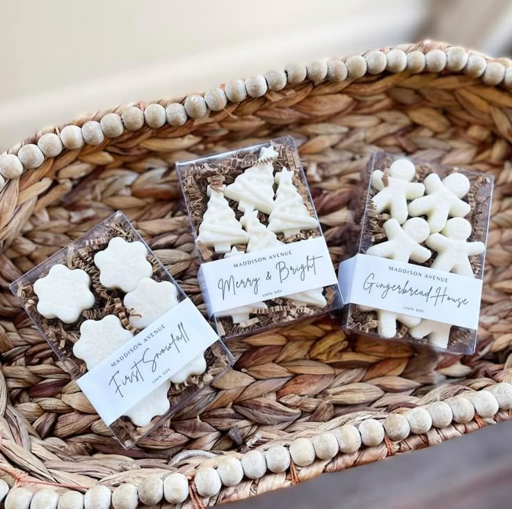 three small white dog bone shaped cookies on a wicker basket with labels for guests