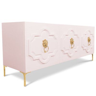 a pink cabinet with gold handles and lion heads on it's doors, against a white background