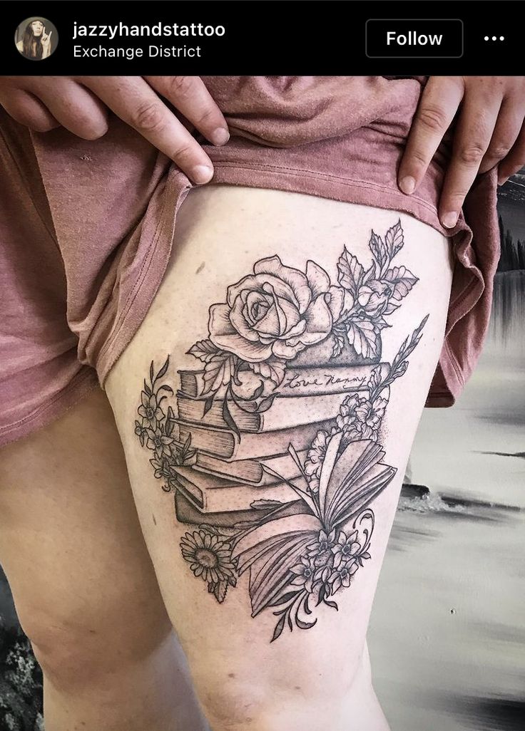 a woman's thigh with books and flowers on it