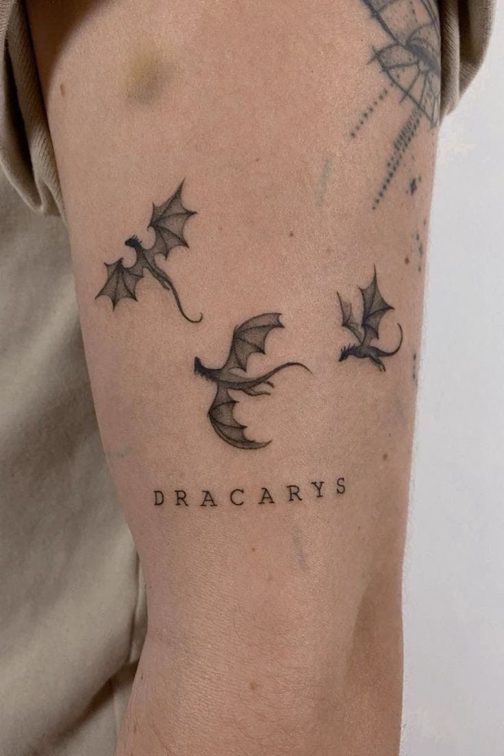 a man with a tattoo on his arm that saysdracary's and two flying bats