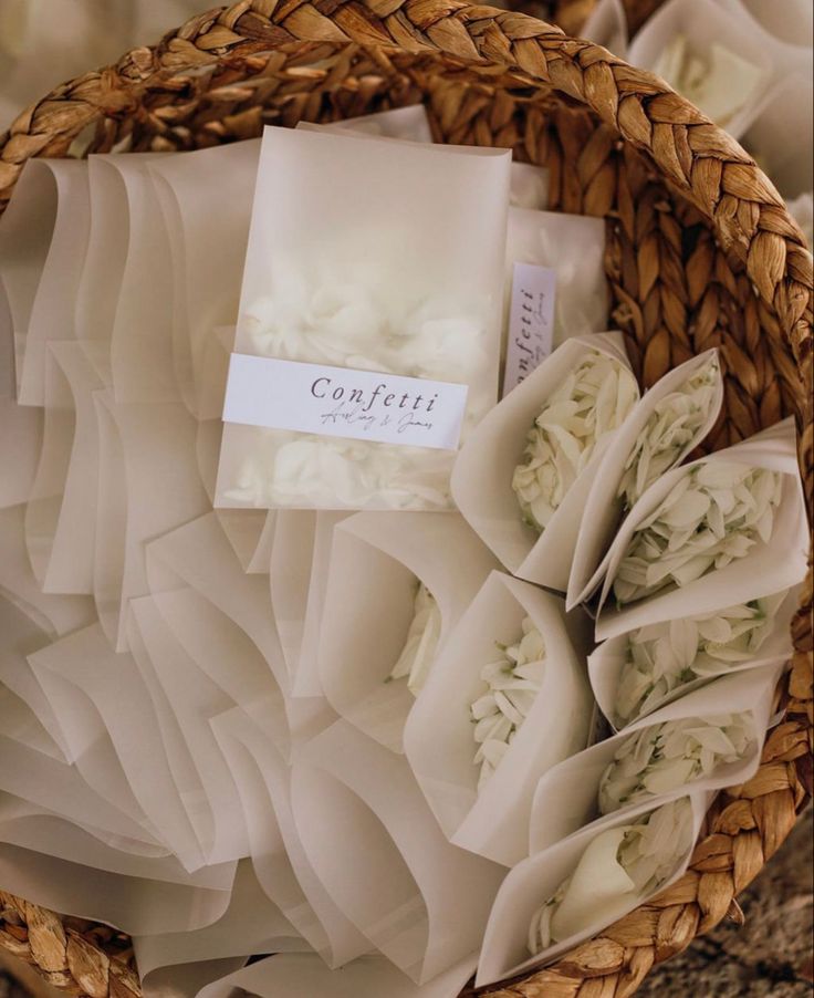 a basket filled with lots of white flowers next to a sign that says confetti