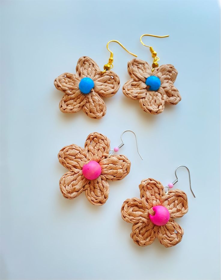 three crocheted flower earrings with pink and blue bead accents on white background