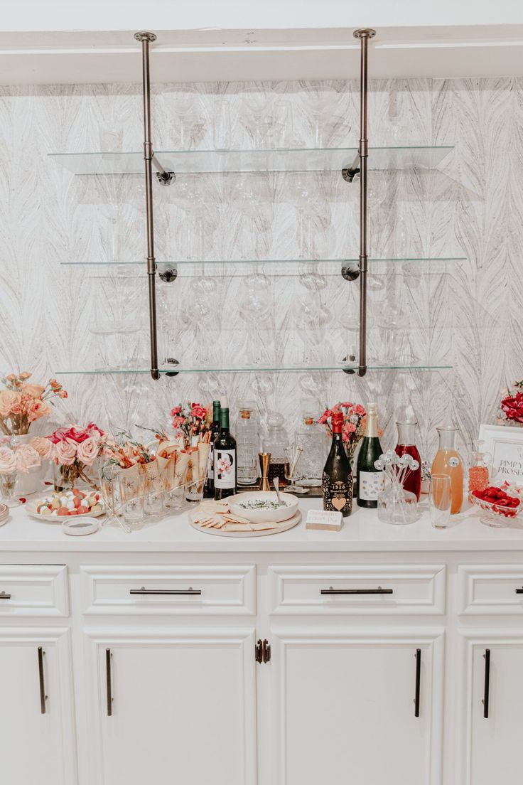 a white buffet table topped with lots of food and drinks