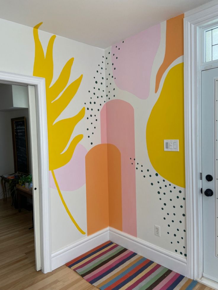 an entryway with colorful wallpaper and rugs on the floor next to it