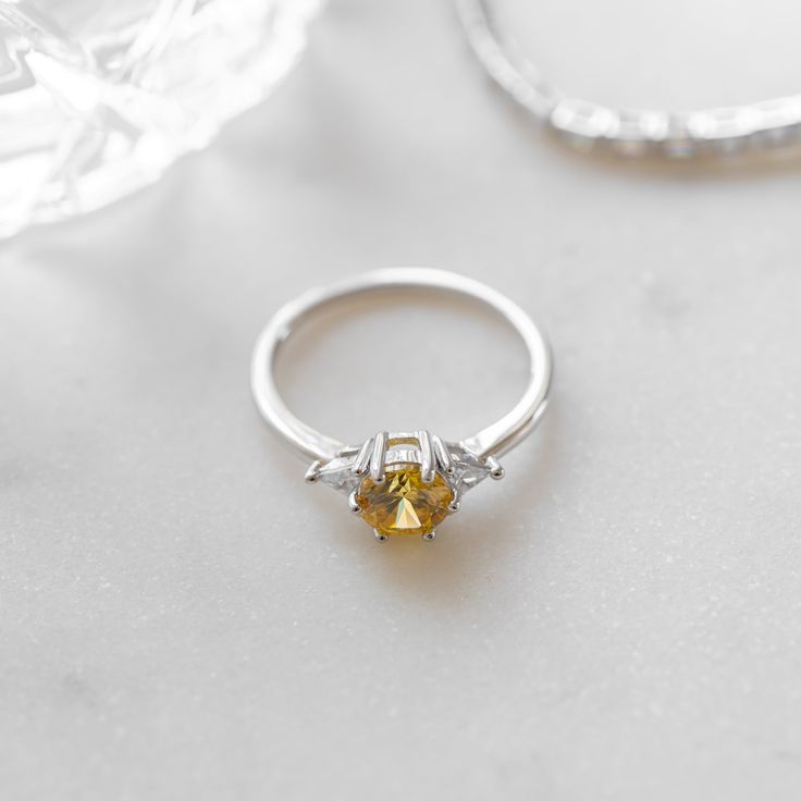 a yellow diamond ring sitting on top of a table