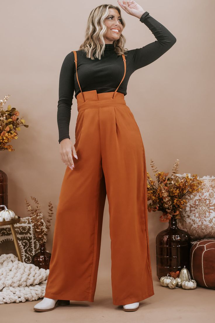 The Setting Trends Suspender Pants in Rust are a trendy and stylish choice for your wardrobe. These suspender pants are perfect for a 30-something mama who loves boutique fashion and wants to make a fashion statement. These pants are a surefire way to set trends and show off your fashion-forward style. Solid Paper Bag High-waist Wide Leg Suspender Pants Wide legs Full length Wide banded high waist Side hidden pockets Made in the USA Inseam: Small 30 in Medium 30.50 in Large 30.75 Rise: Small 15. Trendy Bottoms With Pockets For Date Night, Spring Date Night Pants With Pockets, Suspenders Jumpsuits And Rompers For Workwear In Fall, Wide Leg Bottoms With Suspenders For Summer, Trendy Bottoms With Suspenders For Spring, Summer Wide Leg Bottoms With Suspenders, Chic Spring Bottoms With Suspenders, Trendy High-waisted Pants For Date Night, Chic Workwear Jumpsuits And Rompers With Suspenders