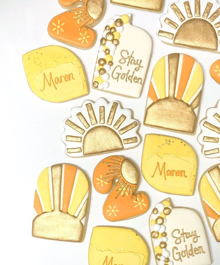 some yellow and white decorated cookies are on a table with gold trimmings that read mom, stay golden