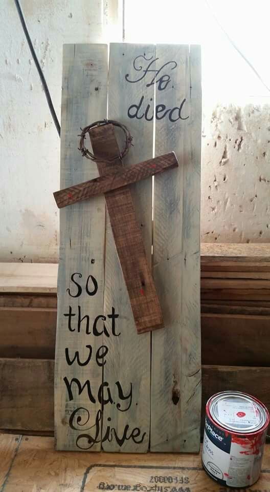 a wooden sign with a crucifix on it next to a can of paint