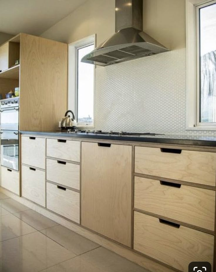 a kitchen with wooden cabinets and stainless steel range hood