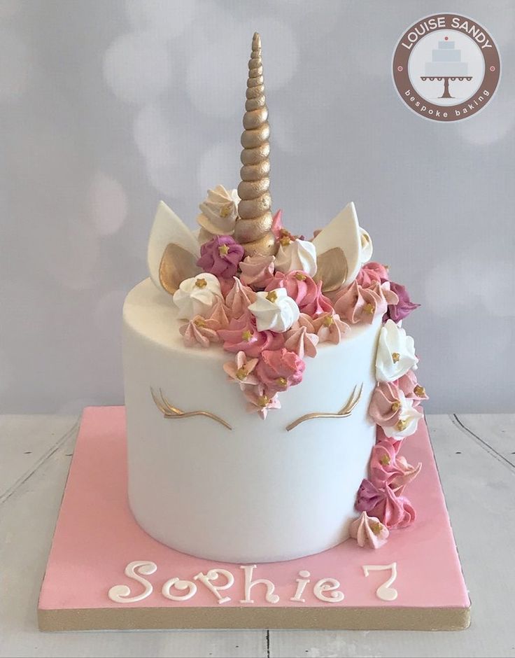 a birthday cake decorated with flowers and a unicorn's horn