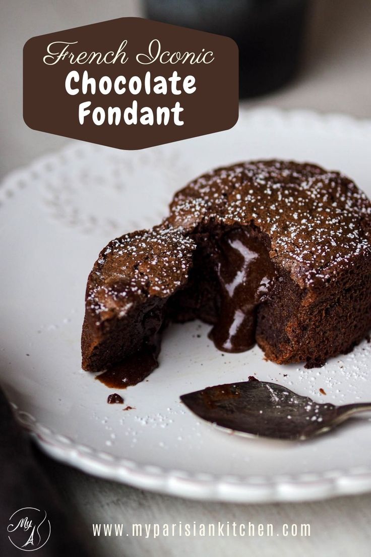 a chocolate fondant cake on a white plate with a bite taken out of it