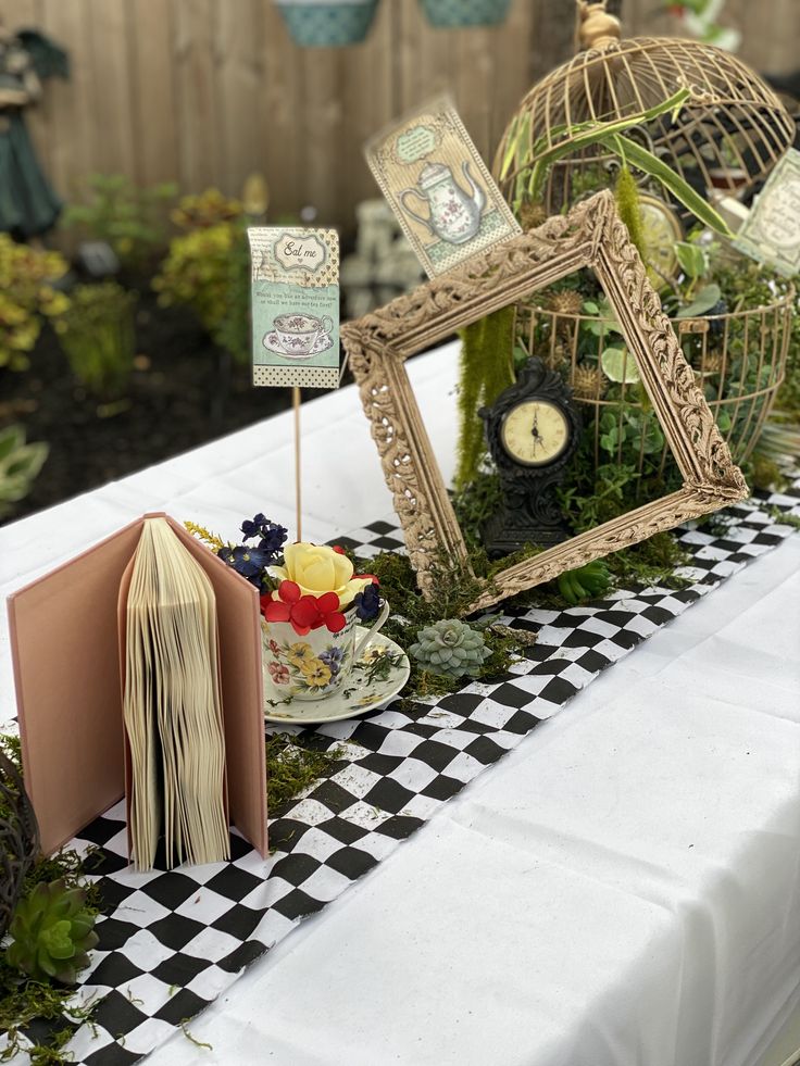 a table topped with an open book next to a birdcage