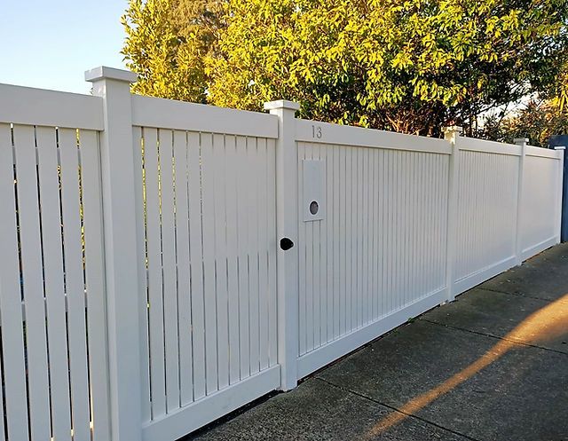 a white fence is shown with the gate closed