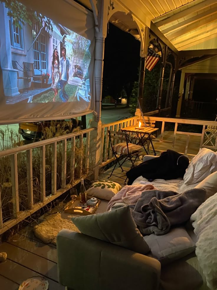 an outdoor movie screen is set up on the porch for people to watch it outside