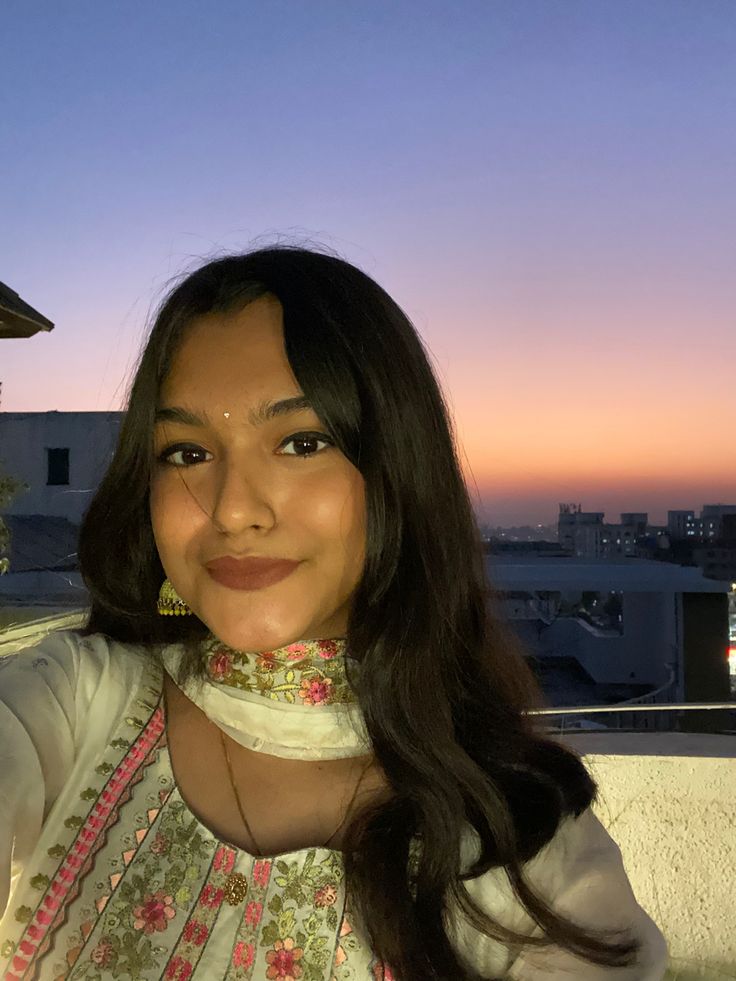 a woman is taking a selfie in front of the sun at sunset or dawn